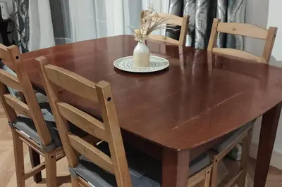 a wooden table with chairs and a vase on it at Apartment - Sleeps 4 - Parking - WiFi in Colchester