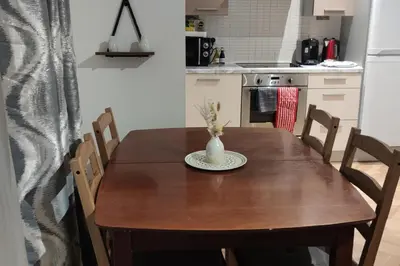 a kitchen with a wooden table with a vase on it at Apartment - Sleeps 4 - Parking - WiFi in Colchester