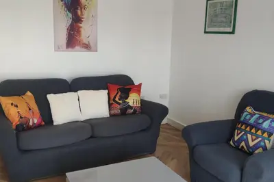 a living room with a blue couch and two chairs at Apartment - Sleeps 4 - Parking - WiFi in Colchester