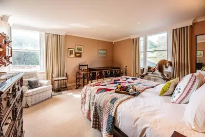 a bedroom with a bed and a piano at 29 Wentworth Road, Aldeburgh in Aldeburgh