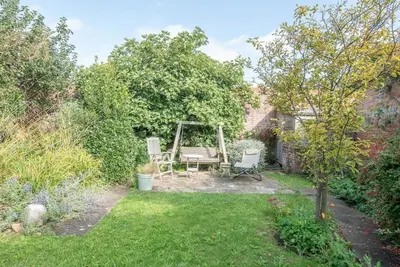 a garden with a bench and a swing at 29 Wentworth Road, Aldeburgh in Aldeburgh