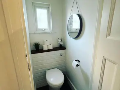 a bathroom with a white toilet and a mirror at Hill Grove 2 Bedroom Apartment in Leigh-on-Sea