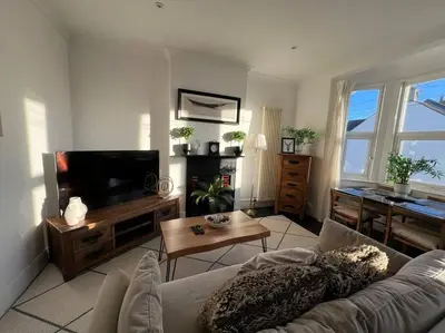a living room with a couch and a tv at Hill Grove 2 Bedroom Apartment in Leigh-on-Sea