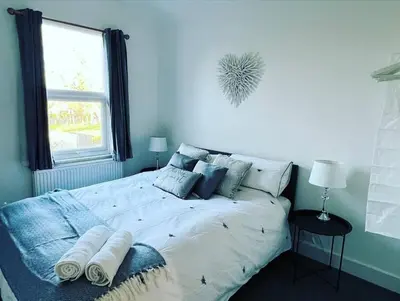 a white bed in a bedroom with a window at Hill Grove 2 Bedroom Apartment in Leigh-on-Sea