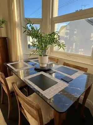 a dining room table with a potted plant on it at Hill Grove 2 Bedroom Apartment in Leigh-on-Sea
