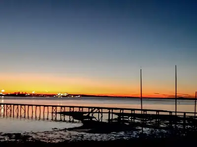 a pier on the water with the sunset in the background at Cherry Cottage in Ipswich