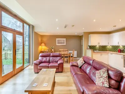 a living room with a couch and a table at Oak Cottage in Ware