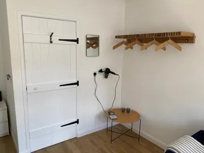 a room with a white door and a table at The Studio in Frinton-on-Sea