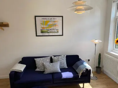 a living room with a blue couch with pillows at The Studio in Frinton-on-Sea