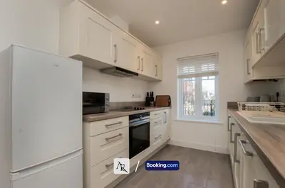 a kitchen with white cabinets and a white refrigerator at 2 Bedroom House By AR Properties Short Lets & Serviced Accommodation Colchester with Garden in Colchester
