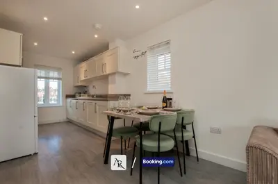 a kitchen with a table and some green chairs at 2 Bedroom House By AR Properties Short Lets & Serviced Accommodation Colchester with Garden in Colchester