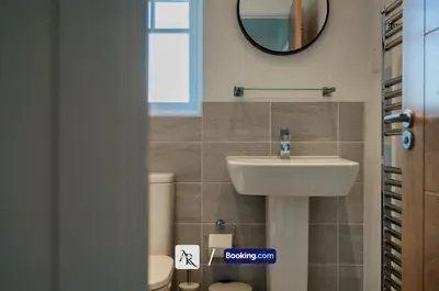 a bathroom with a sink and a toilet and a mirror at 2 Bedroom House By AR Properties Short Lets & Serviced Accommodation Colchester with Garden in Colchester