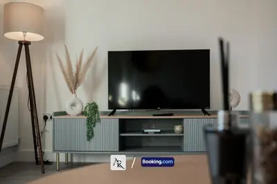 a living room with a flat screen tv on a entertainment center at 2 Bedroom House By AR Properties Short Lets & Serviced Accommodation Colchester with Garden in Colchester