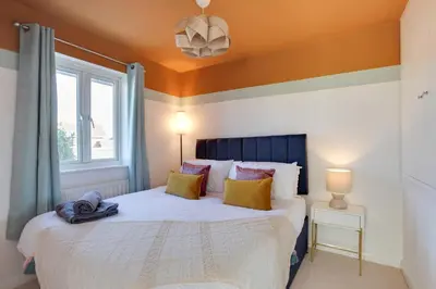 a bedroom with a large bed and a window at Cosy Two bedroom house - Chelmsford - Free Parking and Wifi in Chelmsford
