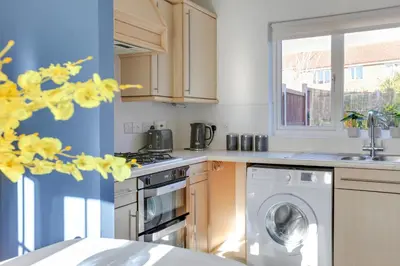 a kitchen with a washing machine and a window at Cosy Two bedroom house - Chelmsford - Free Parking and Wifi in Chelmsford