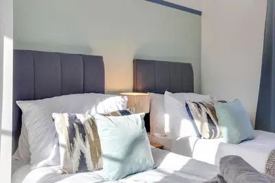 two white beds with pillows in a room at Cosy Two bedroom house - Chelmsford - Free Parking and Wifi in Chelmsford