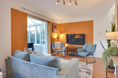 a living room with a couch and chairs and a television at Cosy Two bedroom house - Chelmsford - Free Parking and Wifi in Chelmsford