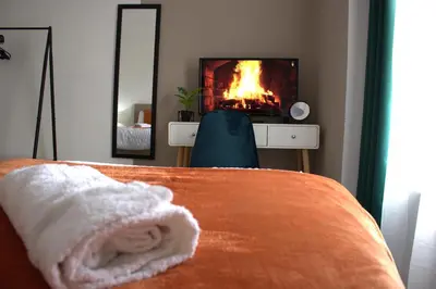 a bedroom with a bed with a fire in the fireplace at Spacious 2BR Apartment Central Colchester Near Station Fast WIFI in Colchester