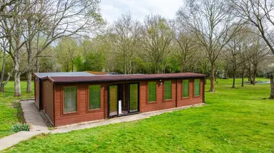a small cabin in a park with green grass at Cabin in the countryside in Sible Hedingham