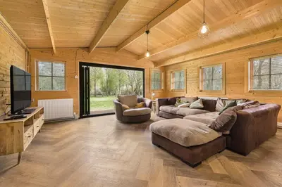 a living room with two couches and a flat screen tv at Cabin in the countryside in Sible Hedingham