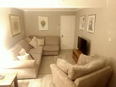 a living room with a couch and two chairs at Lotus House in Needingworth