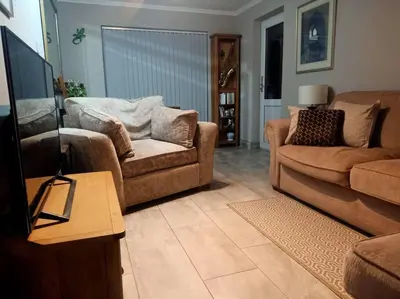 a living room with two couches and a flat screen tv at Lotus House in Needingworth