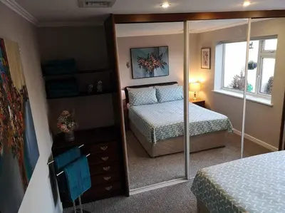 a bedroom with a bed and a large mirror at Lotus House in Needingworth