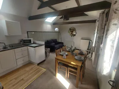 a kitchen and living room with a table and a kitchen and a dining room at Birds Farm in Colchester