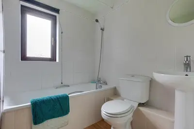 a white bathroom with a toilet and a sink at Birds Farm in Colchester