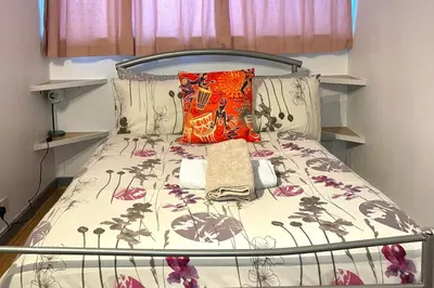 a bed in a small room with a bed frame at House - Sleeps 10 - Garden - Parking in Romford