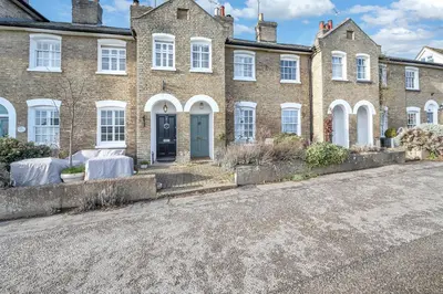 a large brick house with a blue door on a street at Charming Church Walk, Long Melford - 2 bedroom property with parking in Long Melford