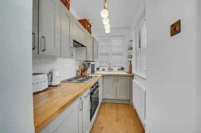 a kitchen with white cabinets and a wooden counter top at Charming Church Walk, Long Melford - 2 bedroom property with parking in Long Melford