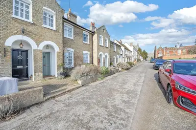 a red car parked in front of a row of houses at Charming Church Walk, Long Melford - 2 bedroom property with parking in Long Melford