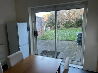 a kitchen with a table and a sliding glass door at Contractor & Family Friendly House Romford in Havering atte Bower