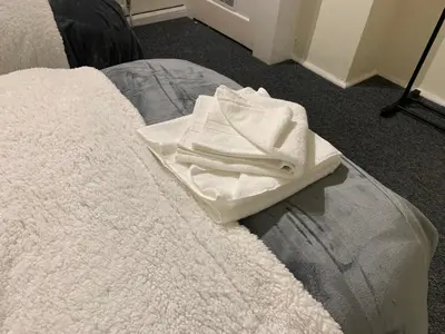 a pair of white towels sitting on a bed at Contractor & Family Friendly House Romford in Havering atte Bower