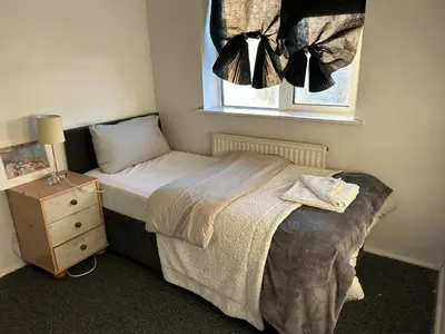 a small bedroom with a bed and a window at Contractor & Family Friendly House Romford in Havering atte Bower