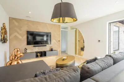 a living room with a couch and a tv at Luxury 2 Bedroom Apartment with AC and Parking in Cambridge