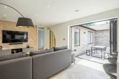 a living room with a large couch and a television at Luxury 2 Bedroom Apartment with AC and Parking in Cambridge