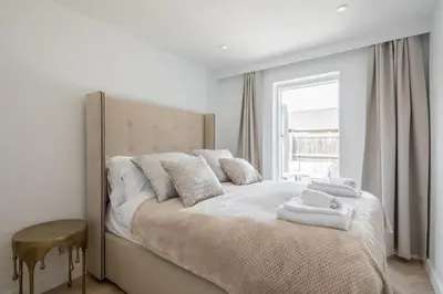 a bedroom with a large bed with two towels on it at Luxury 2 Bedroom Apartment with AC and Parking in Cambridge