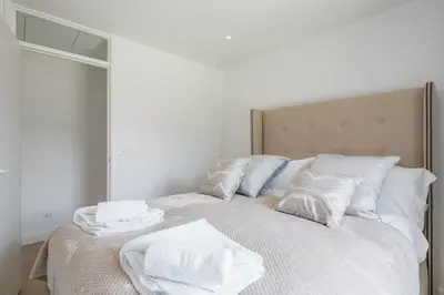 a bed with white towels on top of it at Luxury 2 Bedroom Apartment with AC and Parking in Cambridge