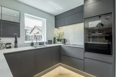 a kitchen with black and white cabinets and a window at Luxury 2 Bedroom Apartment with AC and Parking in Cambridge