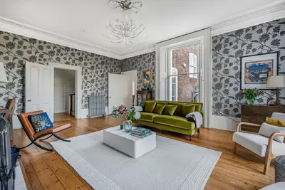 a living room with a green couch and a table at London- Large Period Town House with river front in Hertford