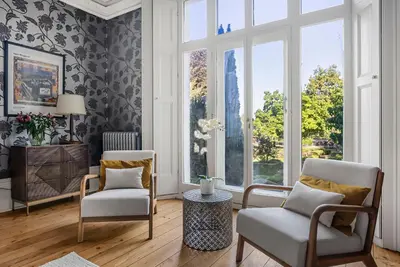 a living room with two chairs and a large window at London- Large Period Town House with river front in Hertford
