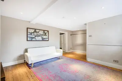 a living room with a white couch and a rug at London- Large Period Town House with river front in Hertford