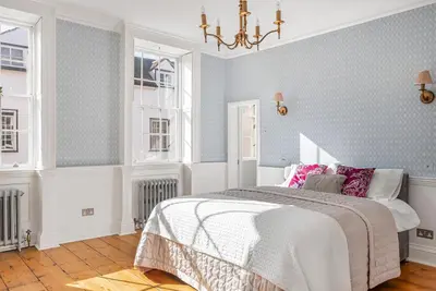 a bedroom with a bed and a chandelier at London- Large Period Town House with river front in Hertford