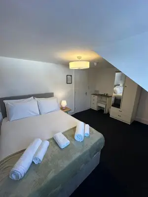 a bedroom with a large white bed with two pillows at Cambridge Central Rooms - Tas Accommodations in Cambridge
