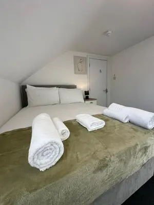 a bedroom with a bed with two towels on it at Cambridge Central Rooms - Tas Accommodations in Cambridge