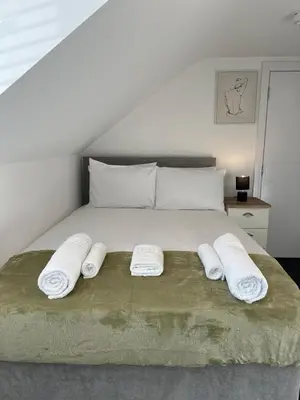 a bedroom with a bed with two towels on it at Cambridge Central Rooms - Tas Accommodations in Cambridge