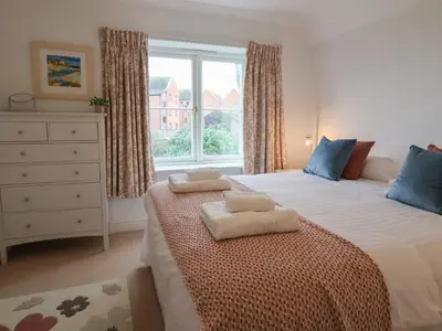 a bedroom with a large bed with two towels on it at 9 Church Farm Rise in Aldeburgh