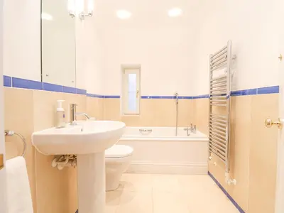 a bathroom with a sink and a toilet and a tub at 9 Church Farm Rise in Aldeburgh
